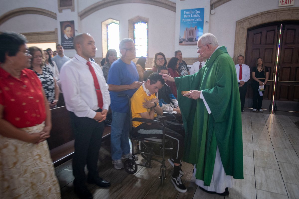 Archbishop José H. Gómez blesses a man with developmental disabilities during Fuerza Inc.'s 40th anniversary Mass at St. Matthias Church in Huntington Park on Oct. 18, 2026. (Michael Goulding)