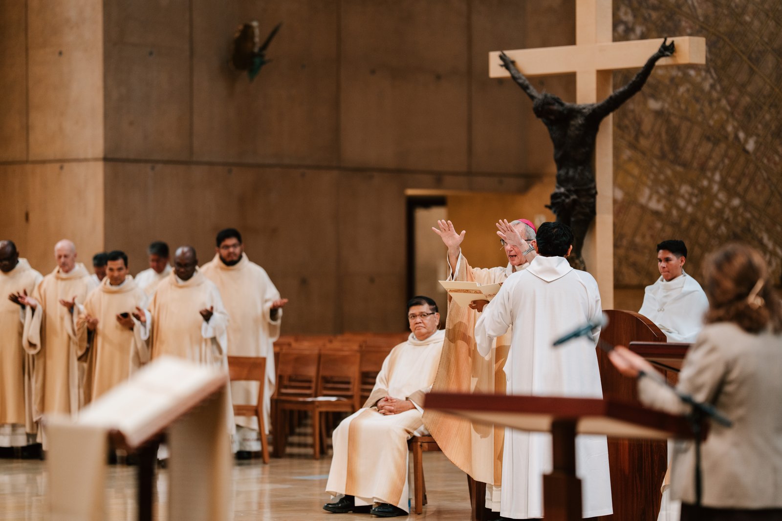 Bishop Marc Trudeau raises his hands to give a blessing to those attending the Mass