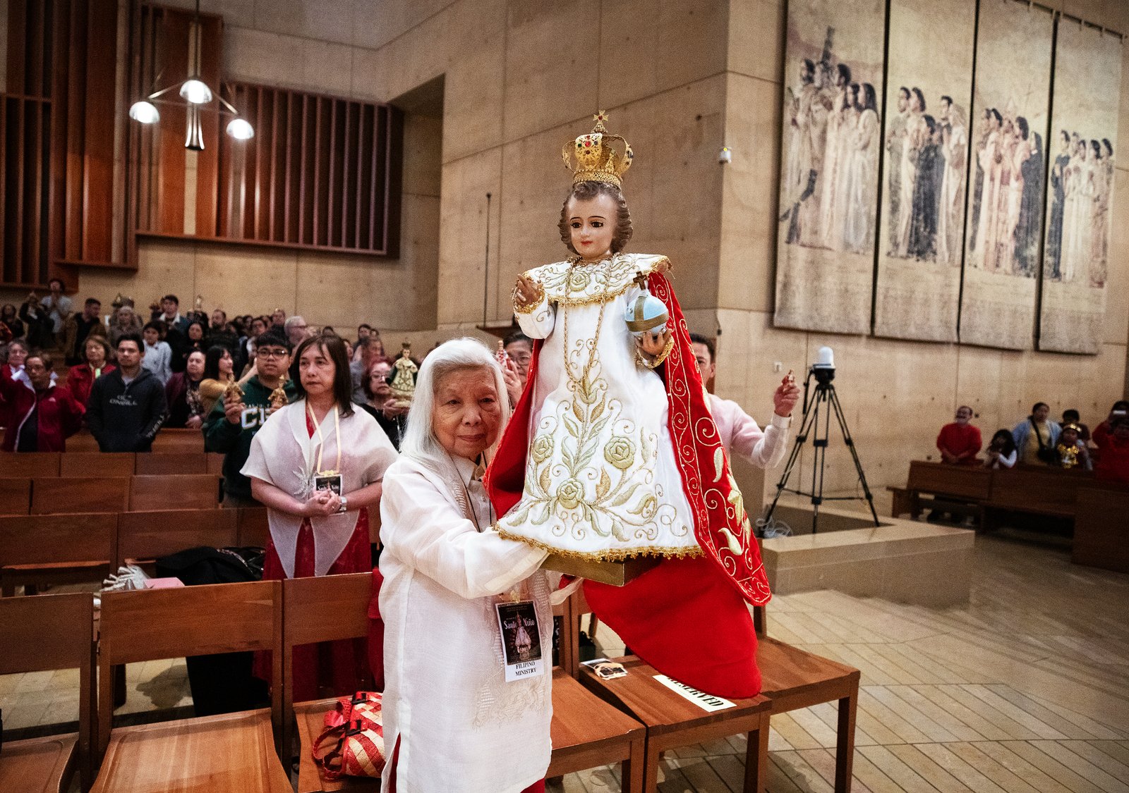 A celebrant at the Feast of Santo Niño Mass holds up her statue to be blessed during the event at the Cathedral of Our Lady of the Angels on Jan. 21. (Victor Alemán)
