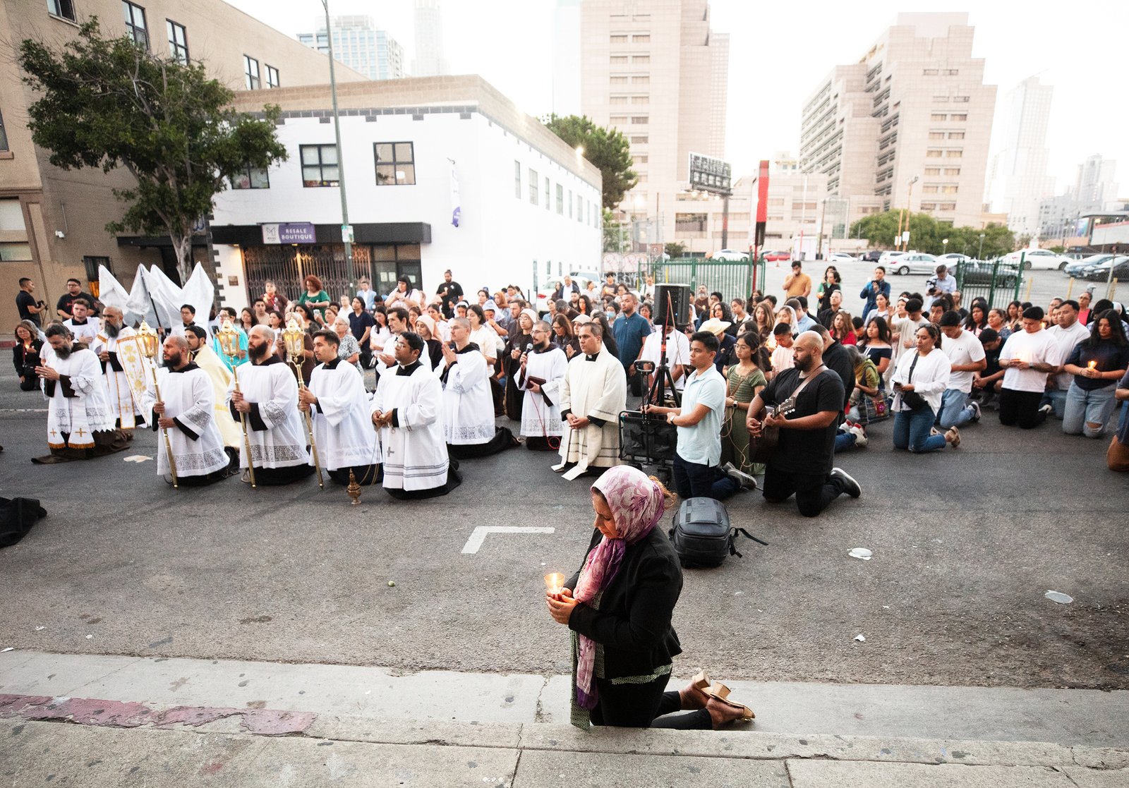 More than 300 priests, seminarians, and lay Catholics kneel in front of the Blessed Sacrament during a Eucharistic Procession through downtown LA’s Skid Row on Saturday, July 27. (Victor Alemán)