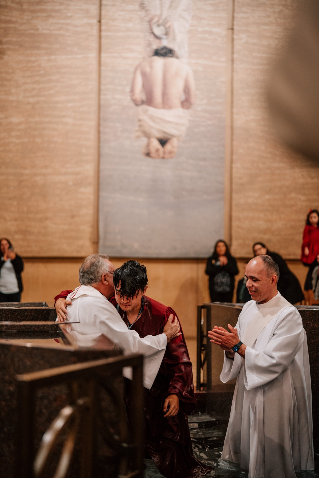 A catechumen is baptized into the Church stand at the Cathedral of Our Lady of the Angels during the Easter Vigil Mass on April 19. (Peter Lobato)