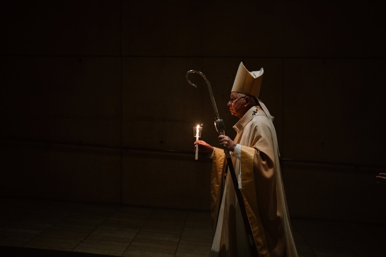 Archbishop José H. Gomez carries a candle while leading the faithful into the Cathedral of Our Lady of the Angels for the Easter Vigil Mass on April 19. (Peter Lobato)