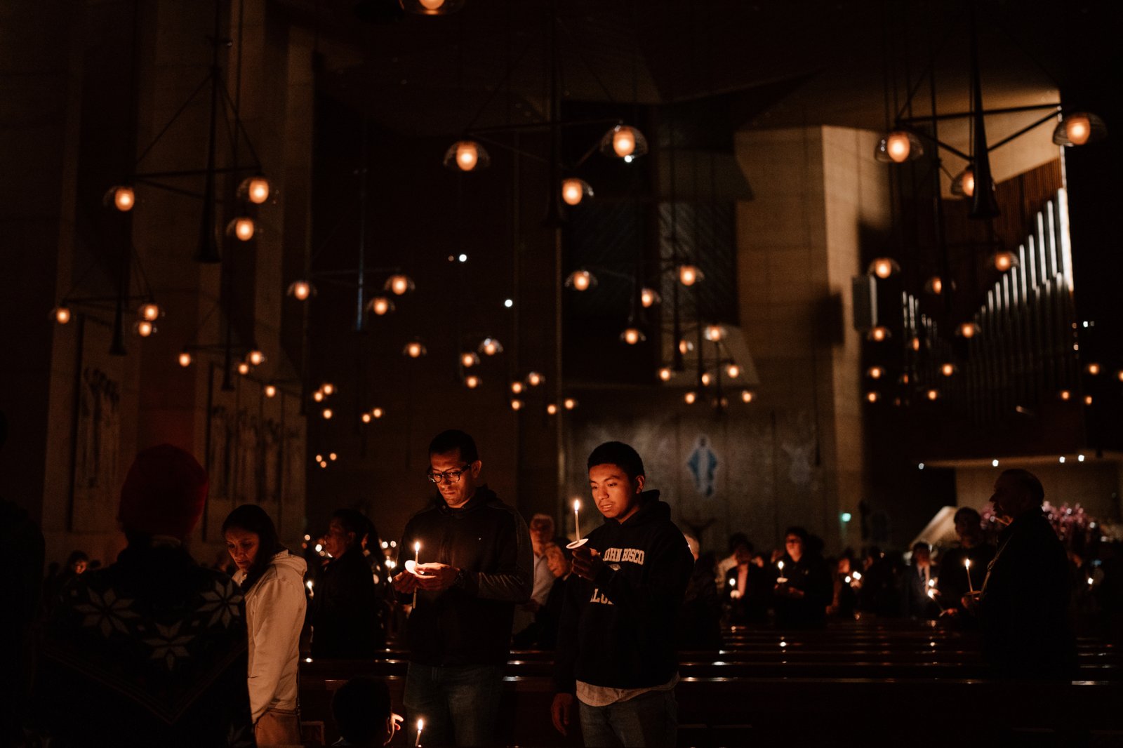 Attendees carry candles at the Cathedral of Our Lady of the Angels for the Easter Vigil Mass on April 19. (Peter Lobato)