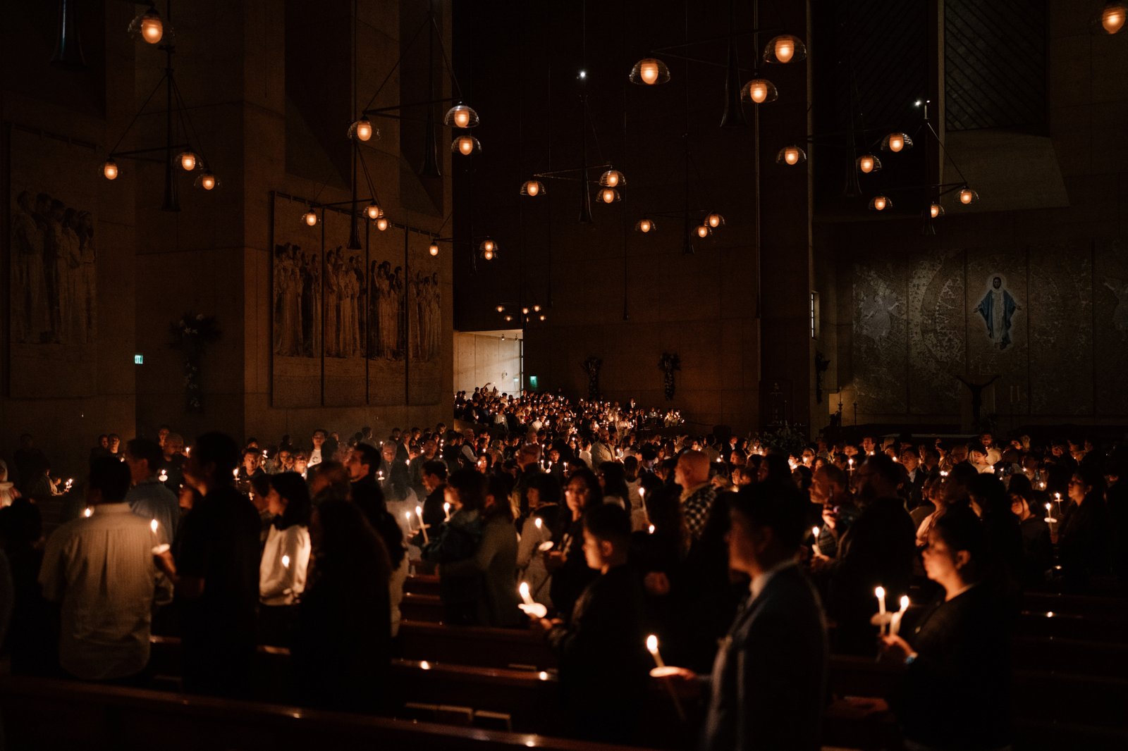 Attendees carry candles at the Cathedral of Our Lady of the Angels for the Easter Vigil Mass on April 19. (Peter Lobato)