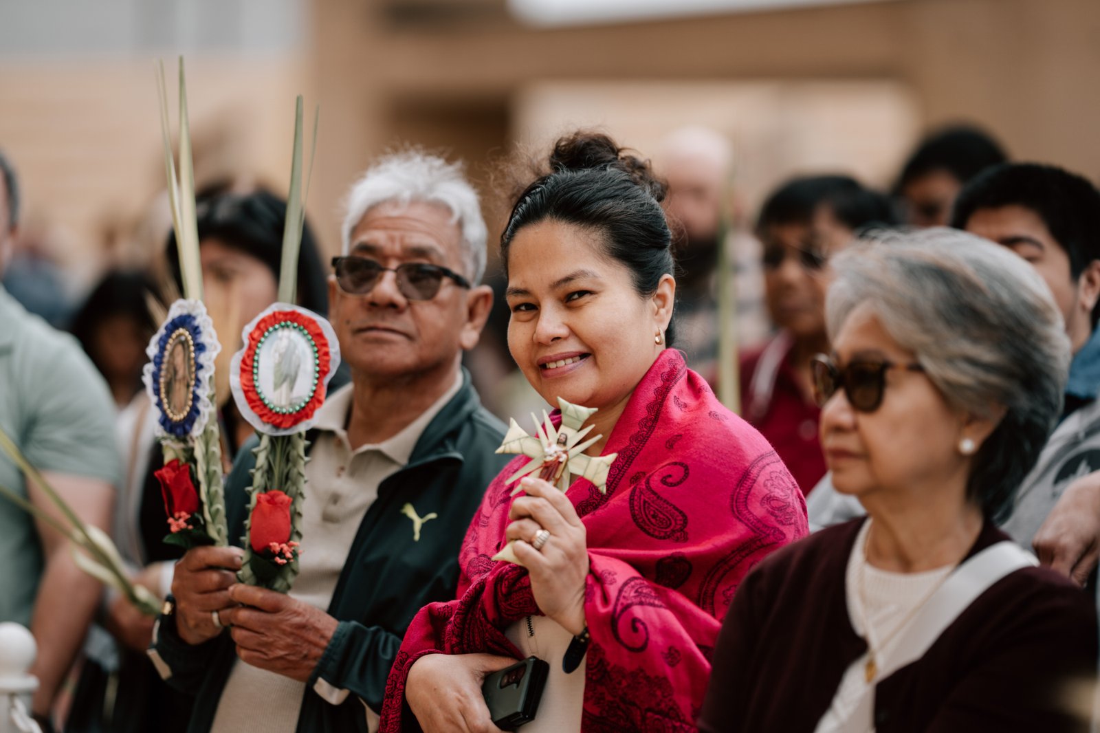A woman holds up a cross made from palms during the Palm Sunday celebration at the Cathedral of Our Lady of the Angels on April 13. (Peter Lobato)