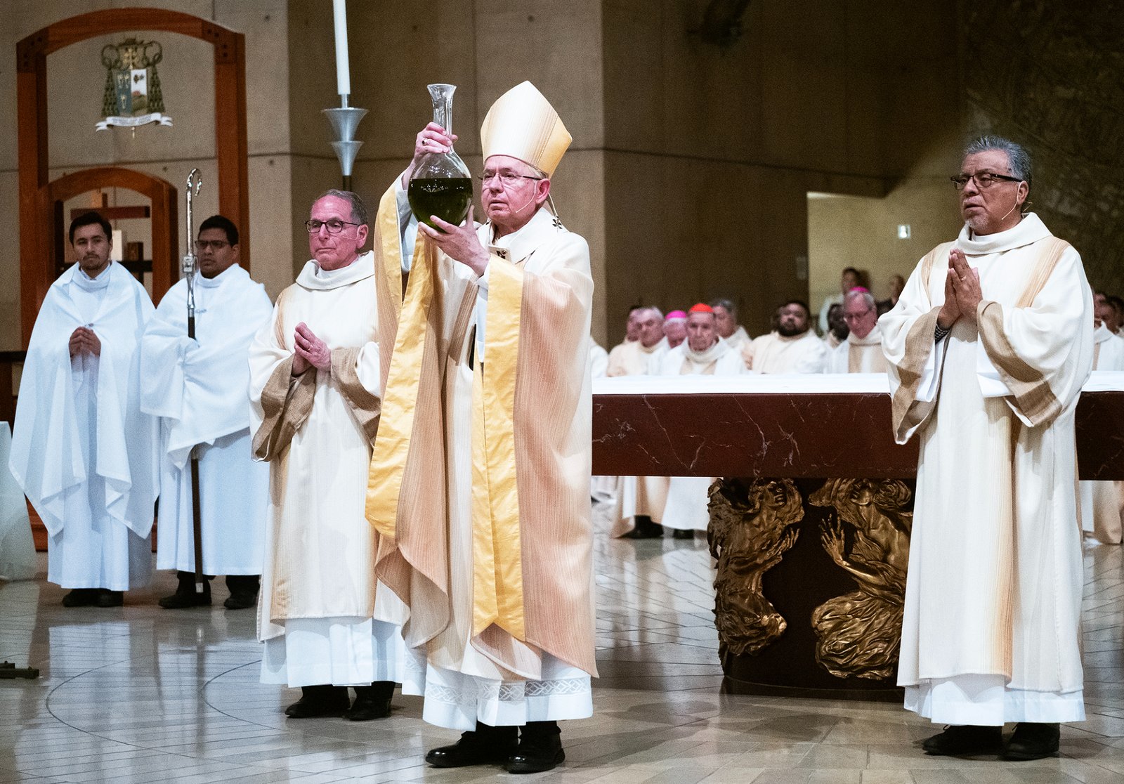 Archbishop José H. Gomez holds up a jar of oil to be blessed during the Chrism Mass at the Cathedral of Our Lady of the Angels on April 14. (Victor Alemán)