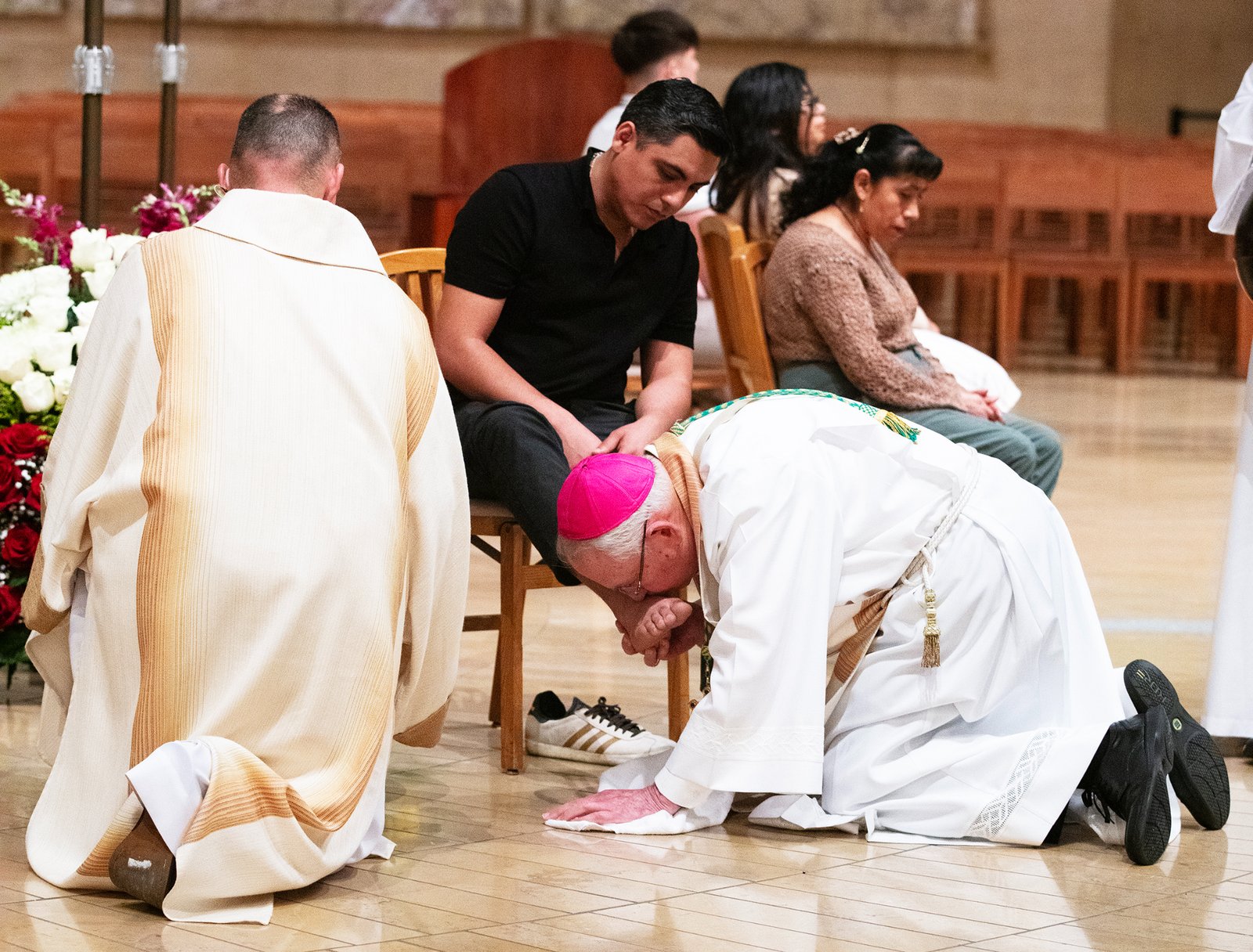 Archbishop José H. Gomez kisses the feet of a parishioner after washing their feet during the Mass of the Lord’s Supper at the Cathedral of Our Lady of the Angels on April 17. (Victor Alemán)