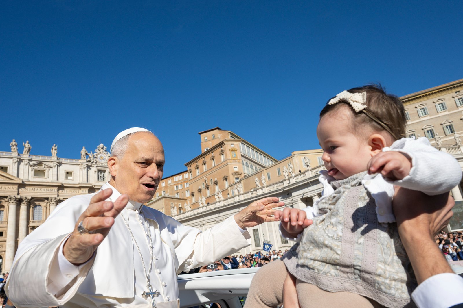 Pope Leo XIV greets a child as he rides the popemobile around St. Peter's Square at the Vatican before an audience for the Jubilee of Migrants and the Jubilee of the Missions Oct. 4, 2025. (CNS photo/Vatican Media)