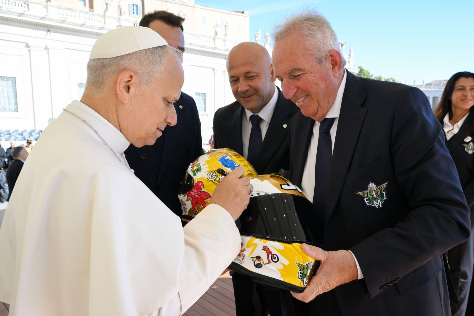 Pope Leo XIV signs a helmet for a representative of the Italian Motorcyclists' Federation after an audience for the Jubilee of Migrants and the Jubilee of the Missions Oct. 4, 2025. (CNS photo/Vatican Media)