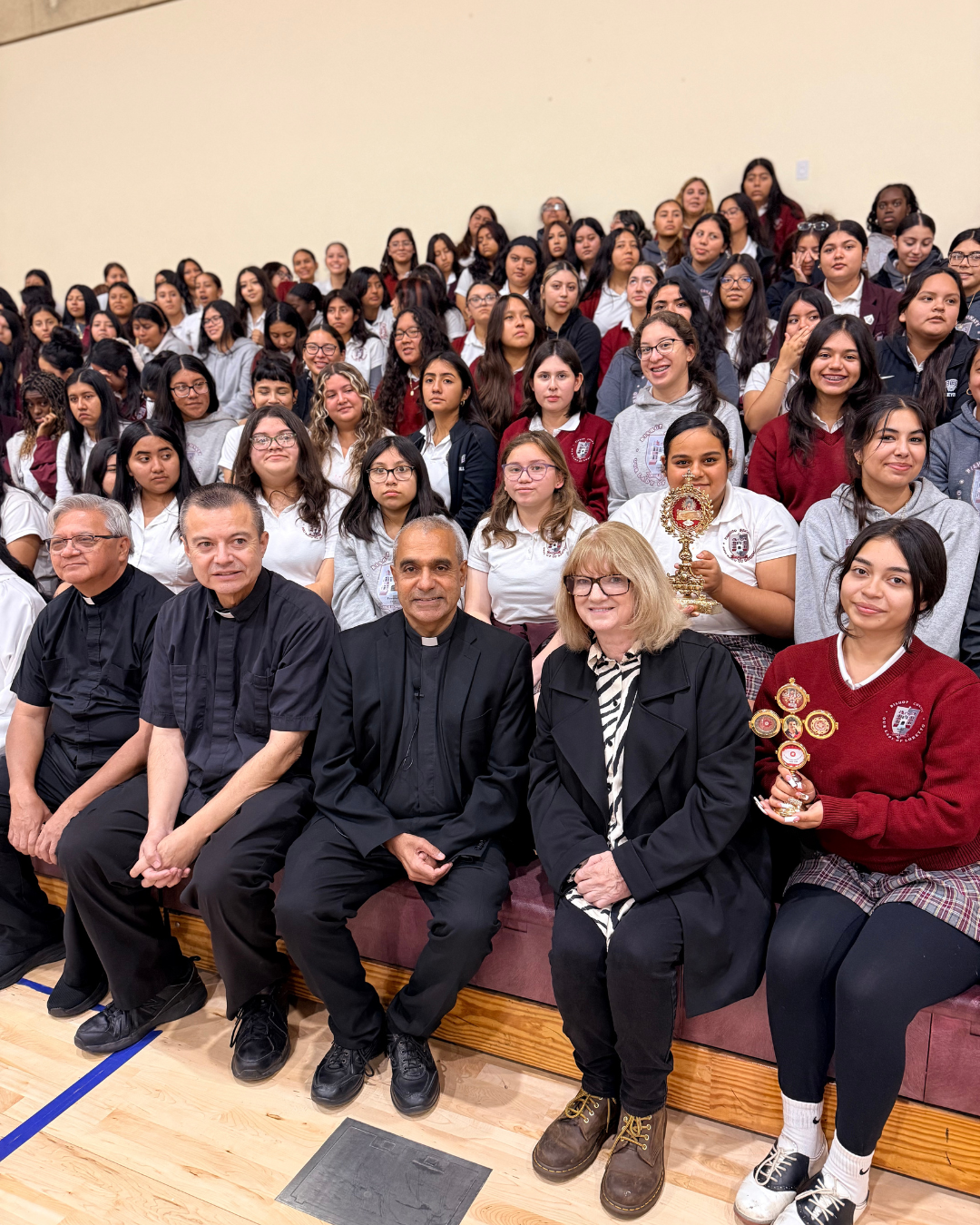 Msgr. Anthony Figueiredo, front center, Father Mario Torres, center left, and Father Michael Semana, far left, pose with Principal Robyn Carroll and students with the relics of St. Carlo Acutis at Bishop Conaty - Our Lady of Loretto High School on Oct. 21 during a tour of the saint's relics. (Bishop Conaty - Our Lady of Loretto High School)