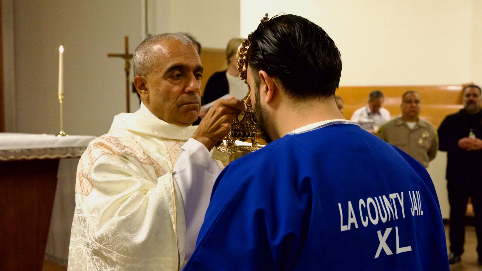 Msgr. Anthony Figueiredo blesses an inmate by holding the reliquary with St. Carlo Acutis’ pericardium to his forehead during the saint's relic visit to LA Men’s Central Jail on Oct. 20. (Reese Cuevas)