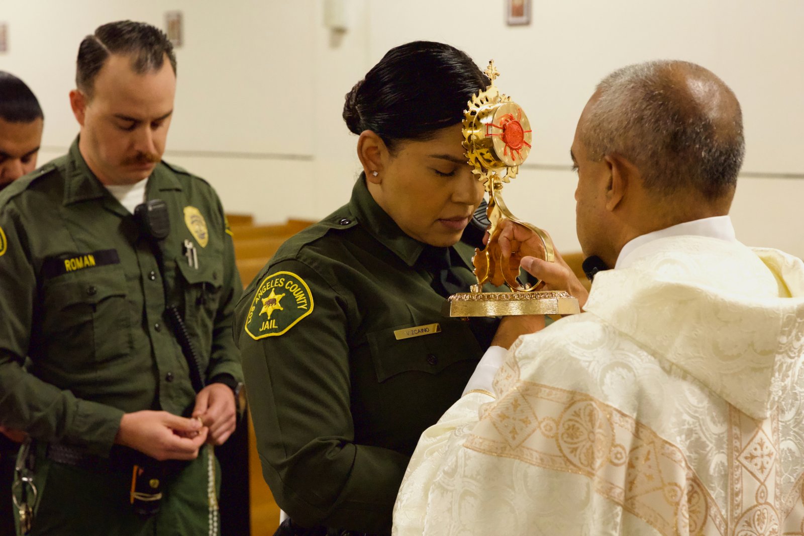 Msgr. Anthony Figueiredo holds the reliquary with St. Carlo Acutis’ pericardium to a sheriff's deputy's forehead during the saint's relic visit to LA Men’s Central Jail on Oct. 20. (Reese Cuevas)