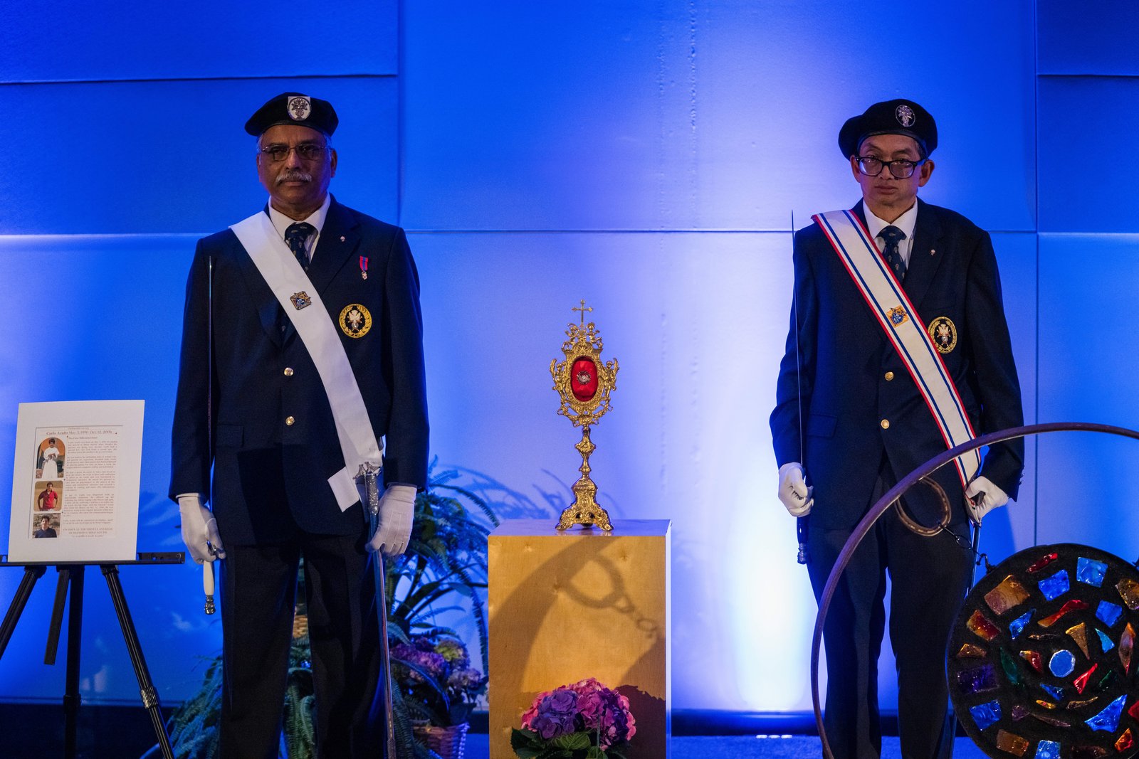 Dos miembros de los Caballeros de Colón vigilan una reliquia de primer grado de cabello del futuro santo Carlo Acutis, expuesta en el Día de la Juventud del Congreso de Educación Religiosa. (Isabel Cacho)