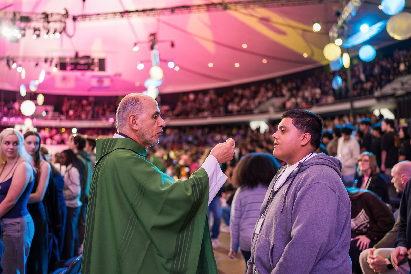 El obispo auxiliar de Los Ángeles, Albert Bahhuth, distribuye la Sagrada Comunión durante la Eucaristía que cerró el Día de la Juventud del Congreso de Educación Religiosa 2025. (Peter Lobato)