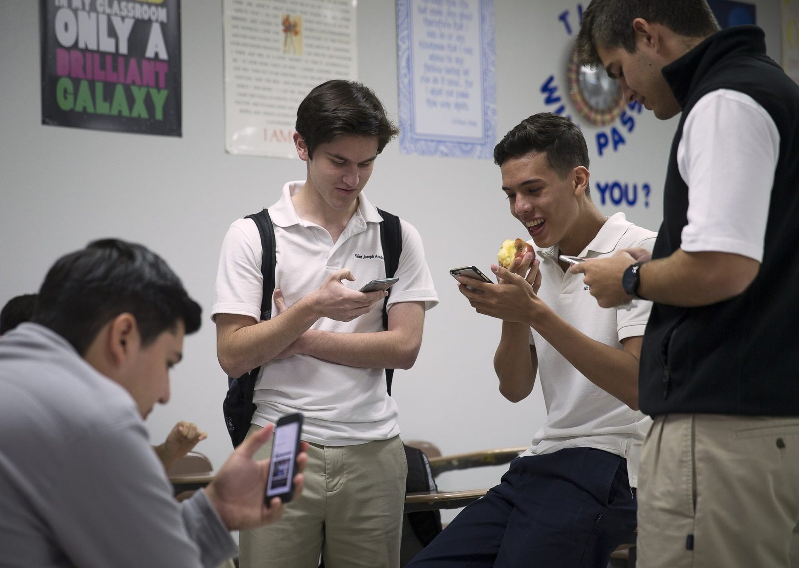 Estudiantes de la Academia St. Joseph en Brownsville, Texas, consultan sus smartphones durante el almuerzo en 2016. (CNS/Tyler Orsburn)