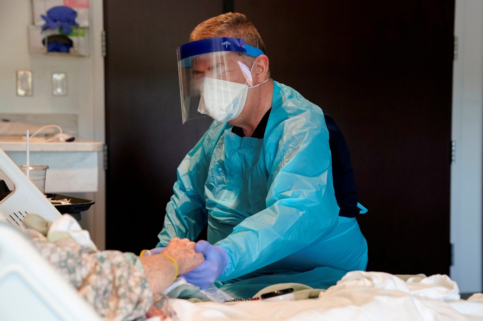 El capellán Bill Simpson de Shawnee, Oklahoma, reza con un paciente sometido a pruebas de coronavirus en el Hospital SSM Health St. Anthony el 23 de abril de 2020. (CNS/Nick Oxford, Reuters)