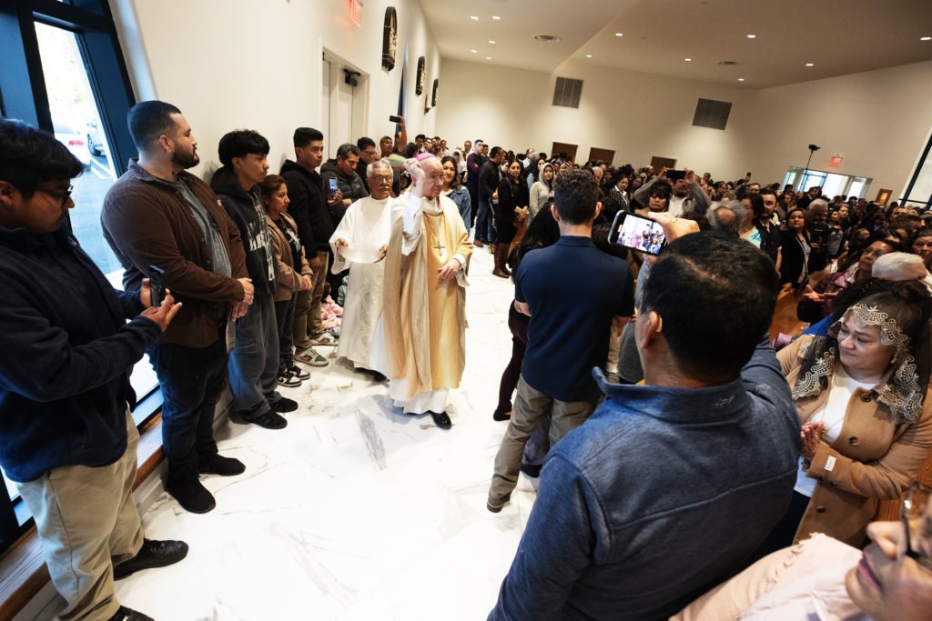 El arzobispo Gómez bendice a los feligreses de Ángel Guardián con agua bendita después de bendecir la pila bautismal de la nueva iglesia durante la Misa de dedicación del 4 de abril. (Victor Alemán)