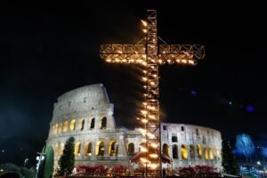 Una gran cruz iluminada se muestra antes del inicio del Vía Crucis fuera del Coliseo en Roma 29 de marzo 2024. (Foto CNS/Lola Gómez)