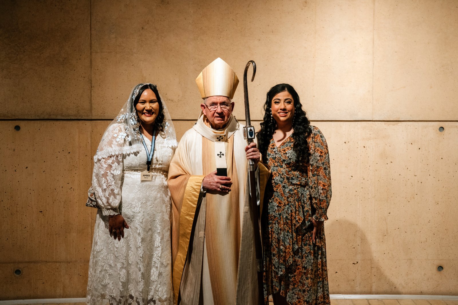 Amber Barnes, izquierda, exprotestante que se convirtió al catolicismo, posa con su madrina, Jessica Luna, derecha, junto al arzobispo José H. Gomez tras la Vigilia Pascual el 19 de abril. (Peter Lobato)