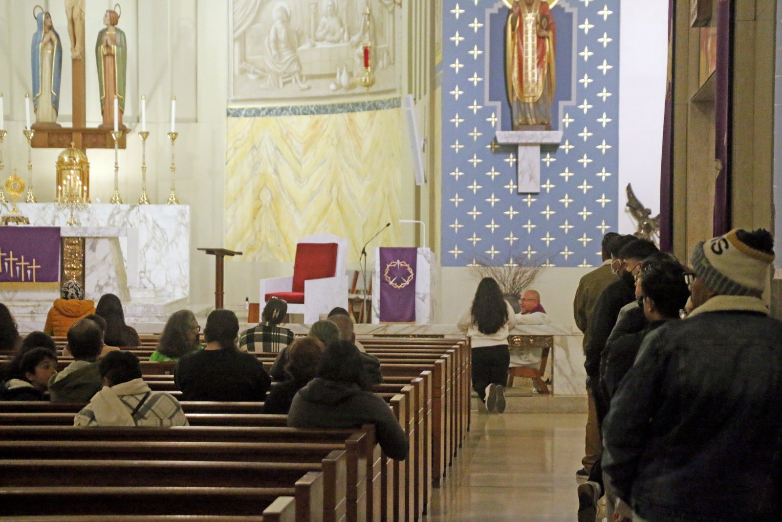 Fieles hacen fila para confesarse mientras el Santísimo permanece expuesto en St. John Chrysostom Church en Inglewood la noche del 28 de marzo. (Pablo Kay)