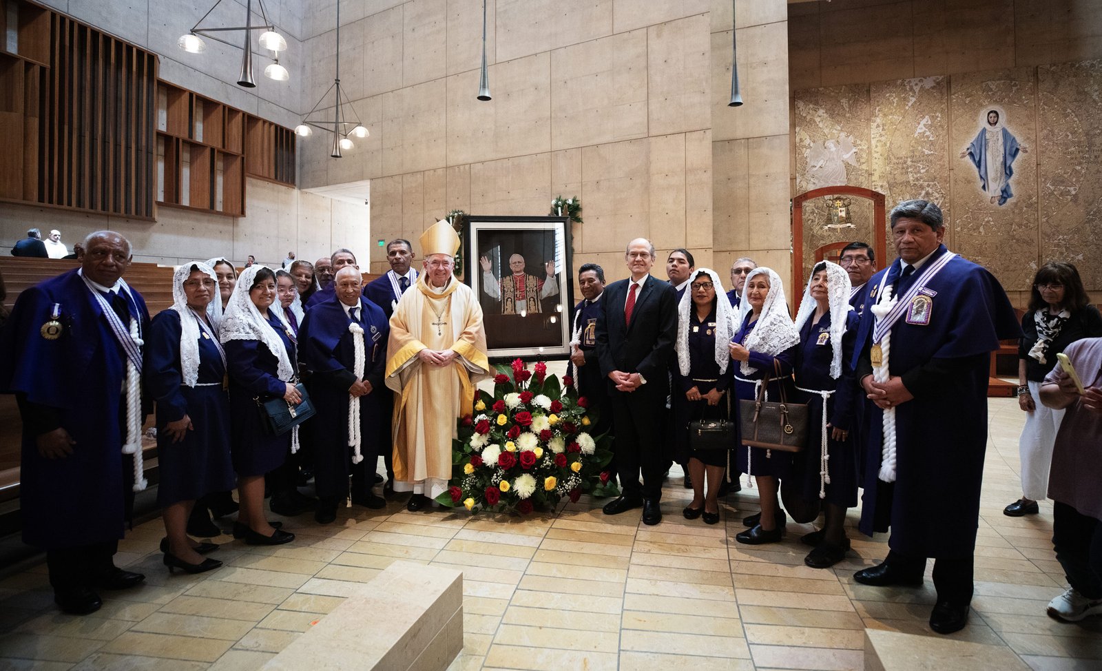Representantes de la organización La Hermandad del Señor de los Milagros y Jaime Casafranca, cónsul general de Perú en Los Ángeles, posan con el arzobispo José H. Gómez alrededor de un retrato del Papa León XIV tras una misa especial de celebración del nuevo pontífice el 9 de mayo. (Víctor Alemán)