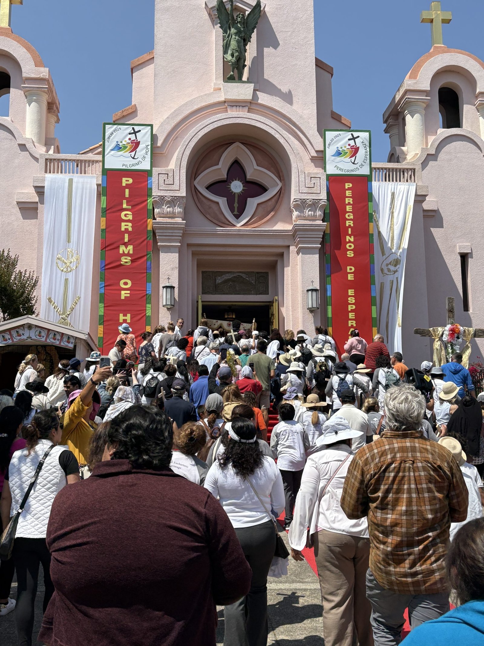 Participantes del Camino de California son recibidos con pancartas de "Peregrinos de la Esperanza" en la Misión San Rafael Arcángel. (Greg Wood)