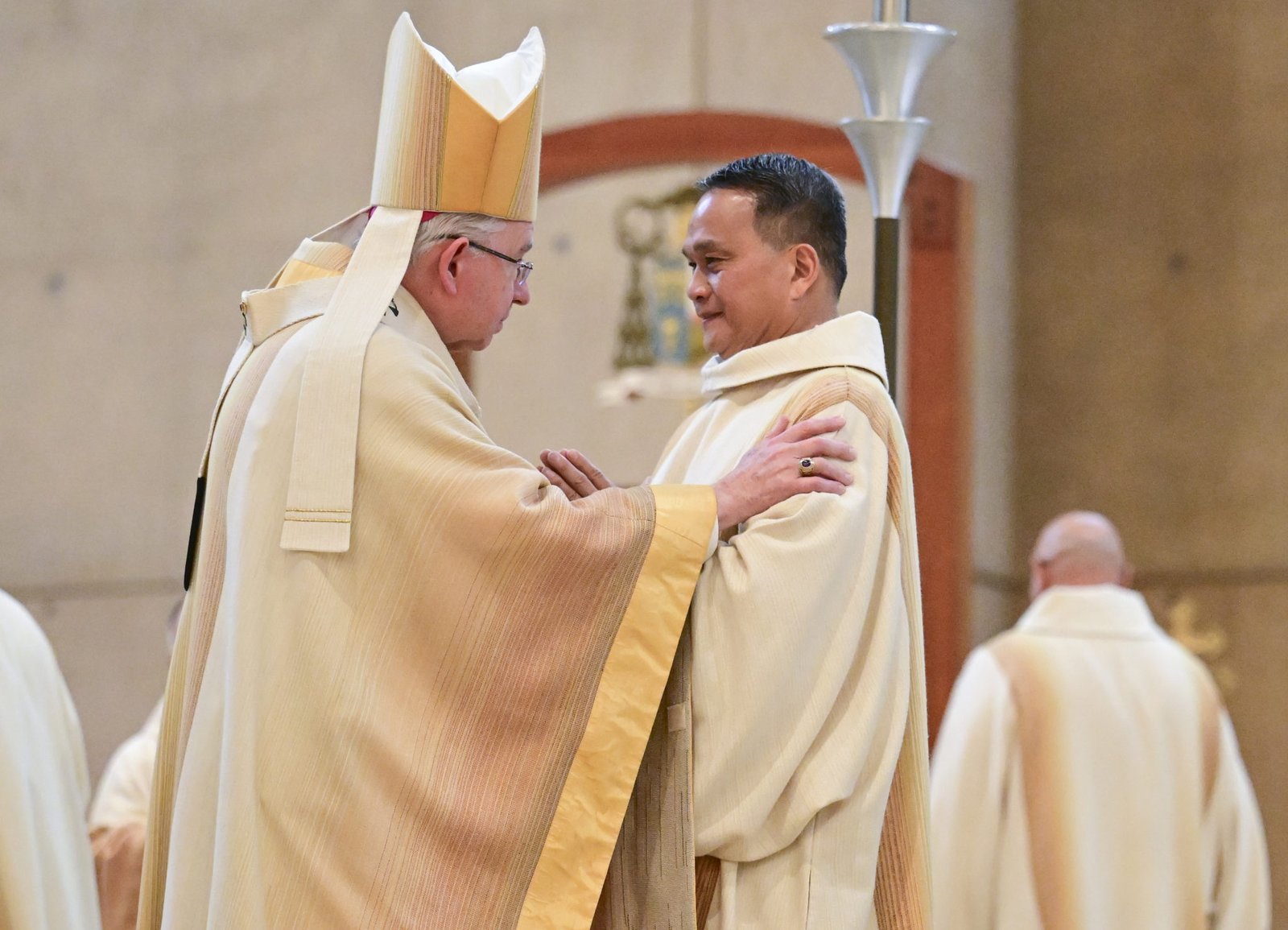 El arzobispo José H. Gomez ofrece el beso de la paz al diácono Dennis Resurreccion durante la Misa de ordenación. (John McCoy)