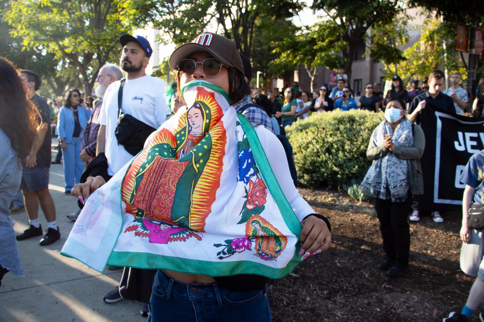 Una mujer sostiene un estandarte de Nuestra Señora de Guadalupe durante la vigilia interreligiosa de oración el 10 de junio en el Grand Park de Los Ángeles. (Kimmy Chacón)