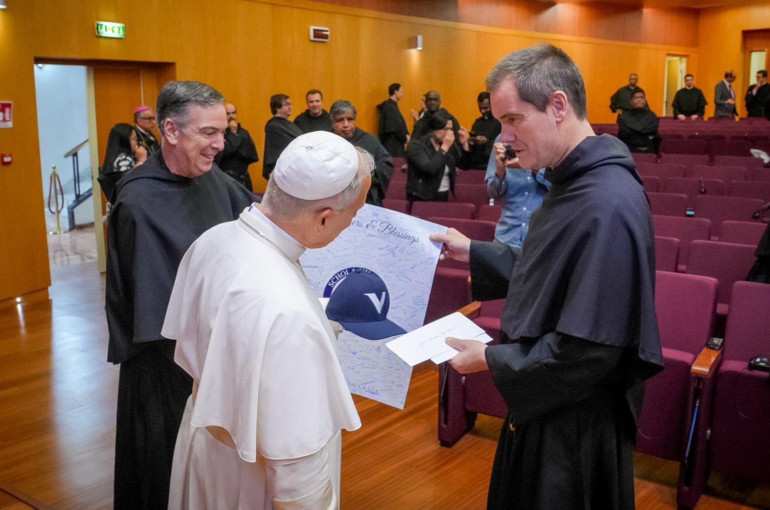 El padre Barnaby Johns, OSA, entrega una gorra y una tarjeta de cumpleaños firmada por estudiantes de la escuela preparatoria Villanova de Ojai al Papa León XIV durante el Capítulo General de los Agustinos en Roma, en septiembre de 2025. (Padre Barnaby Johns, OSA)