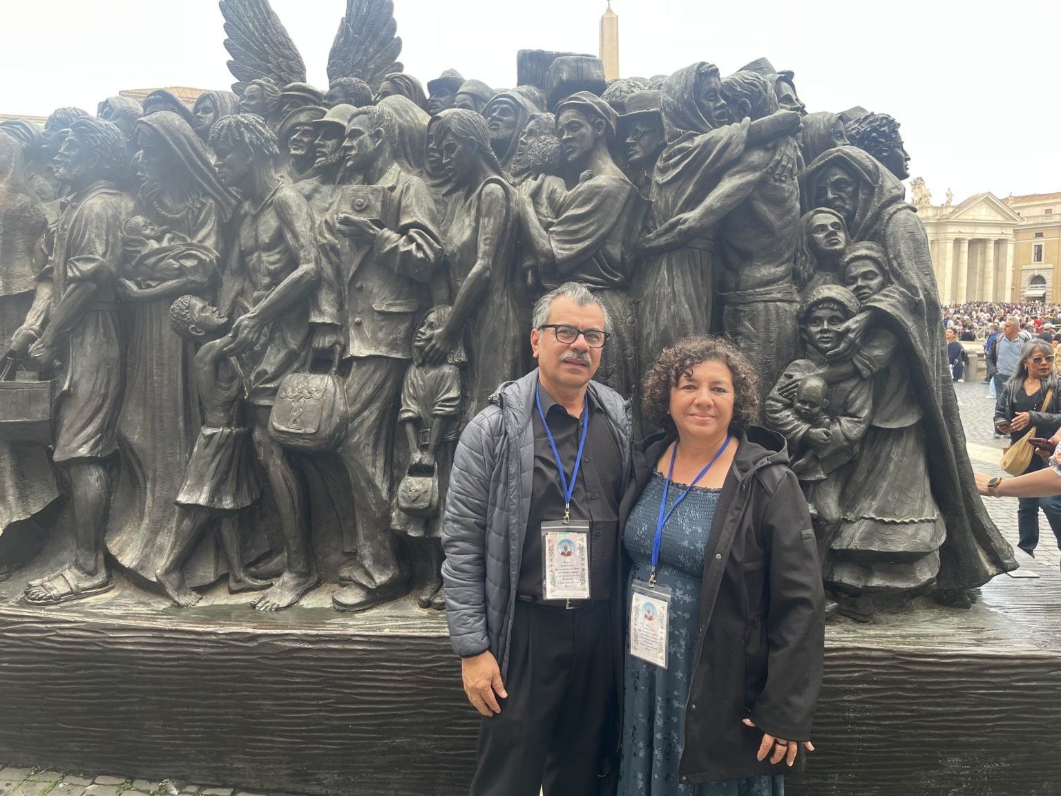 Rosa Bonilla, derecha, y su esposo, Carlos, posan frente a la escultura “Ángeles sin saberlo” en la Plaza de San Pedro en Roma. (Ellie Hidalgo)