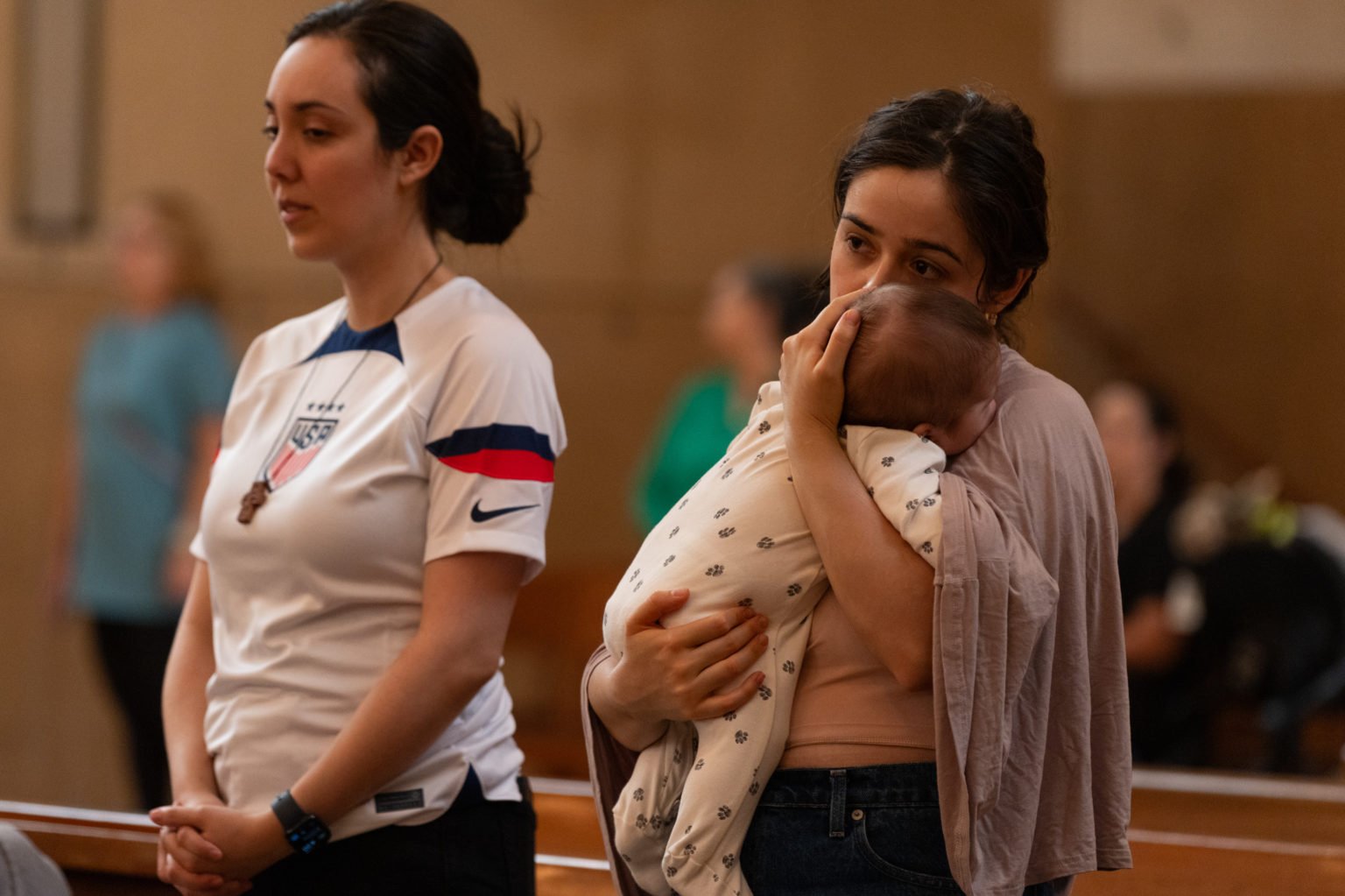 Una madre sostiene a su bebé durante la Misa en Reconocimiento de Todos los Inmigrantes en la Catedral de Nuestra Señora de los Ángeles el 21 de septiembre. (Evan Lirette)