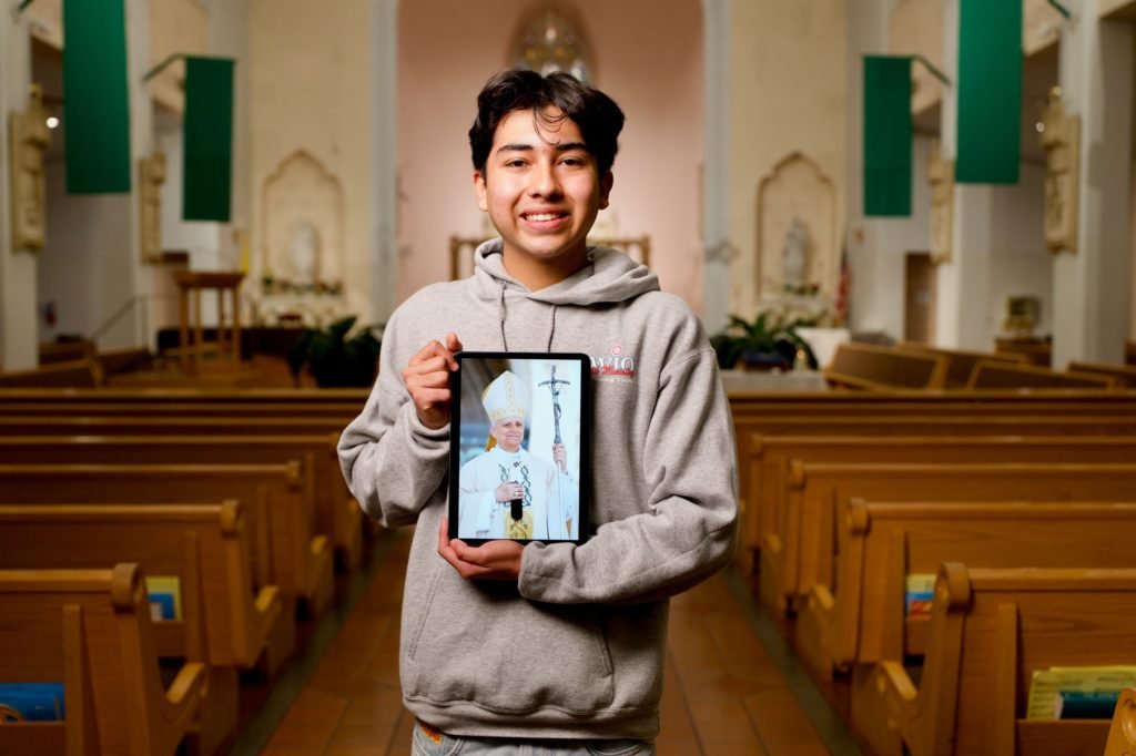 Ezequiel Ponce, de 17 años, con un retrato digital del Papa León XIV en el interior de la iglesia Our Lady of Perpetual Help en Downey. (Reese Cuevas)