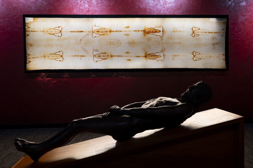 Una réplica de la sábana y una escultura que representa cómo se veía Jesús en el lienzo funerario se exhiben en la Sala de Reflexión. (Everett Johnson / Diocese of Orange)