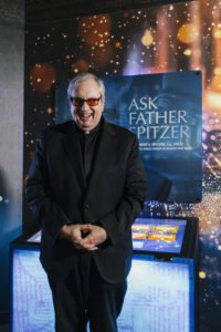 El padre Robert Spitzer, SJ, uno de los principales expertos en la Sábana Santa de Turín, posa frente a su exhibición donde responde preguntas científicas sobre la reliquia. (Everett Johnson / Diocese of Orange)