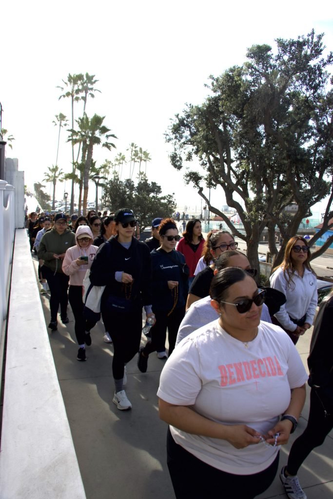Mujeres rezan el primer Misterio Gozoso mientras comienza la Caminata del Rosario para Mujeres a lo largo del paseo marítimo en Manhattan Beach. (Kimmy Chacón)