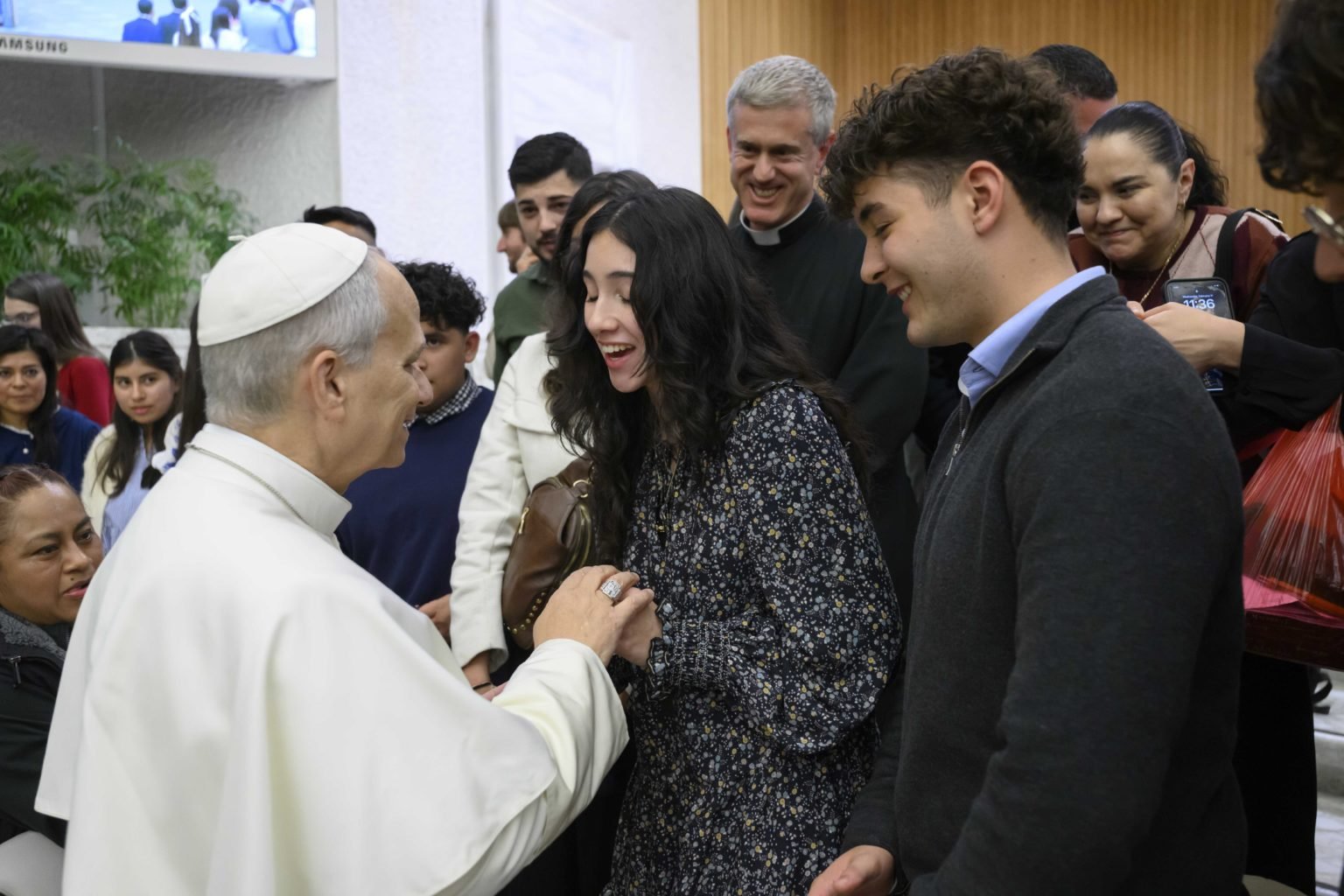 Sophia Gutierrez, al centro, estudiante de último año de Holy Innocents School en Long Beach, California, reacciona tras conocer al Papa León XIV después de la audiencia general en el Aula Pablo VI el 11 de febrero de 2026. El grupo escolar se reunió con el Papa menos de dos semanas después de que su escuela fuera vandalizada y profanada el 2 de febrero. (Foto OSV News/Vatican Media vía CPP)