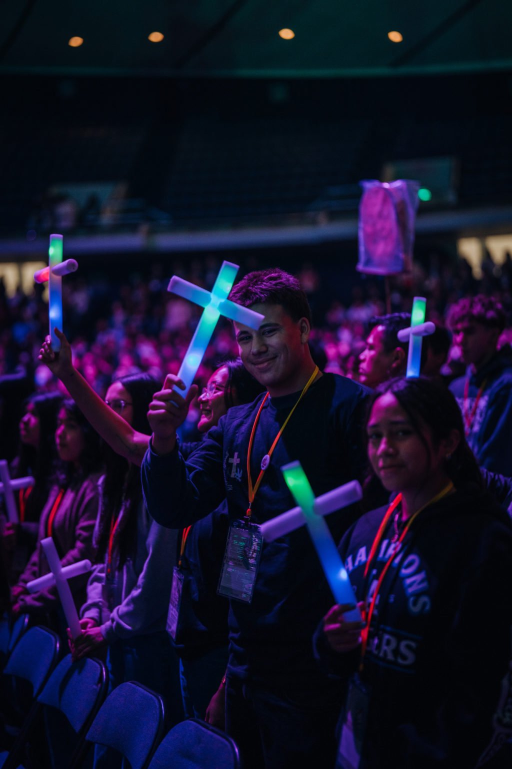 Estudiantes de secundaria levantan cruces fluorescentes durante la Misa en el Youth Day del Congreso de Educación Religiosa el 19 de febrero. (Peter Lobato)