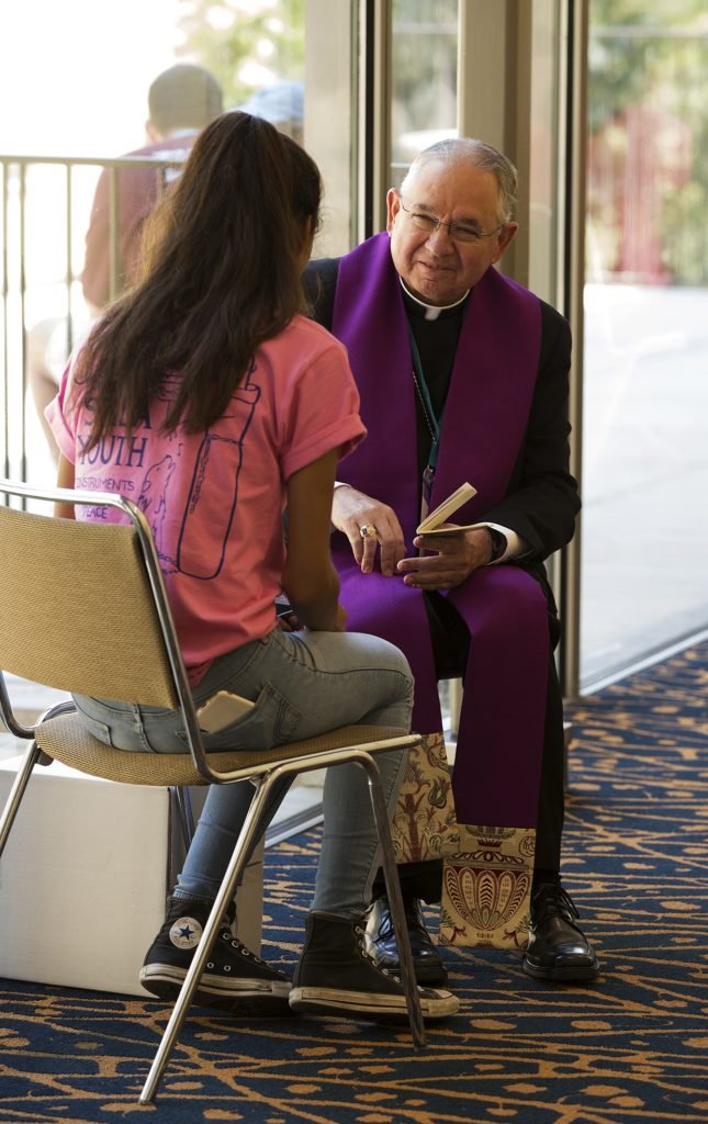 El arzobispo Gómez escucha confesiones durante un evento “City of Saints” para jóvenes católicos en el campus de UCLA en el verano de 2017. (Victor Alemán)