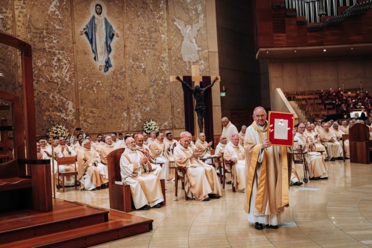 El arzobispo José H. Gómez muestra el mensaje y la bendición apostólica del Papa León XIV al final de la Misa del 26 de marzo de 2026. (Isabel Cacho)