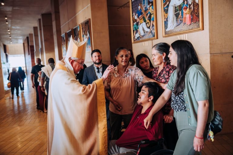 El arzobispo Gómez bendice a una familia después de la Misa del 26 de marzo de 2026. (Isabel Cacho)