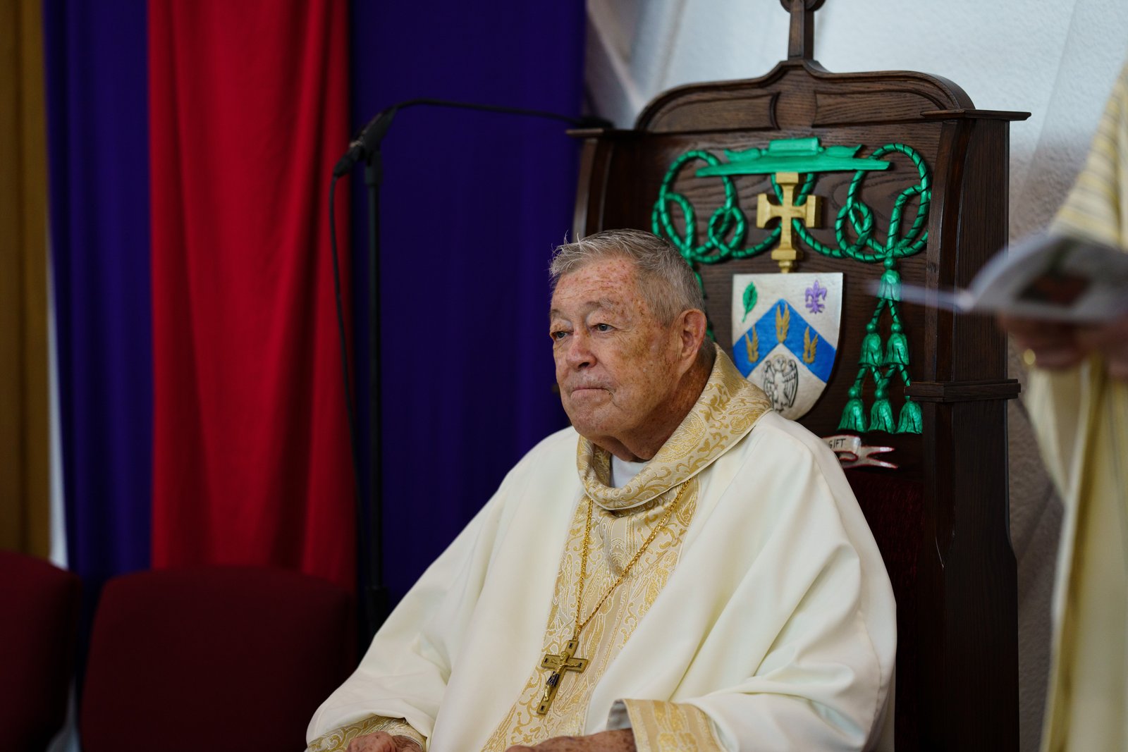 El obispo Clark se sienta en la sede del celebrante, adornada con su escudo episcopal, durante la Misa de Jubileo de Plata. (Peter Lobato)