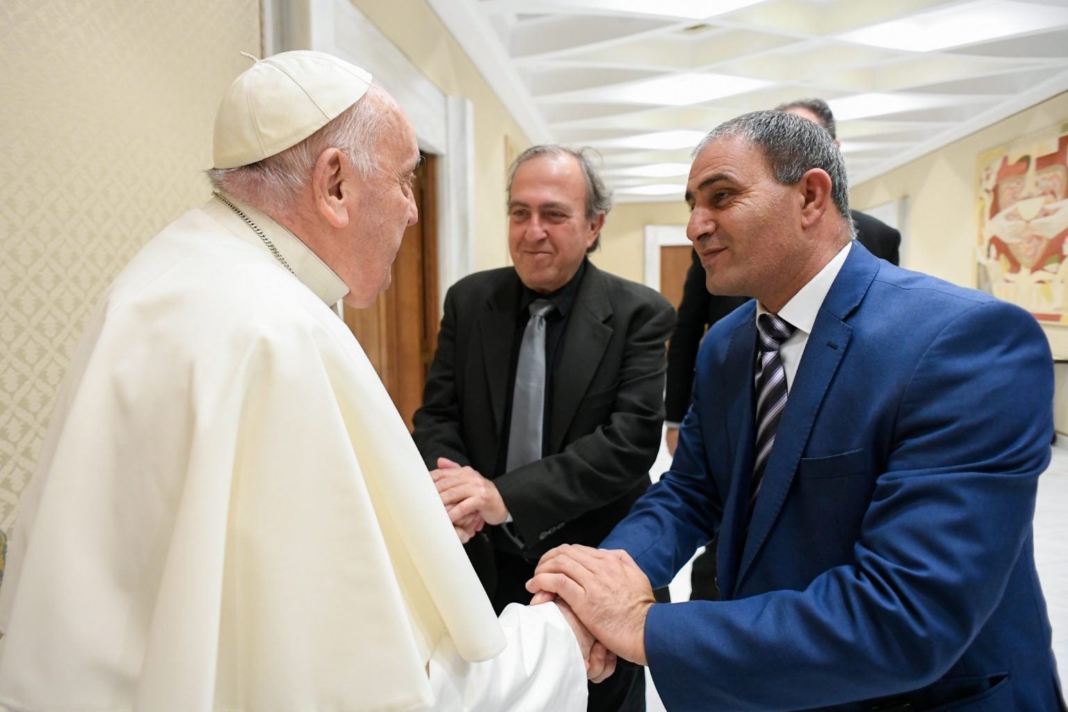 El Papa Francisco se reúne con dos padres que perdieron a sus hijas en conflictos violentos: Bassam Aramin, de Palestina, a la derecha, y Rami Elhanan, de Israel, antes de la audiencia general semanal en el Aula Pablo VI del Vaticano, el 27 de marzo de 2024. (CNS/Vatican Media)