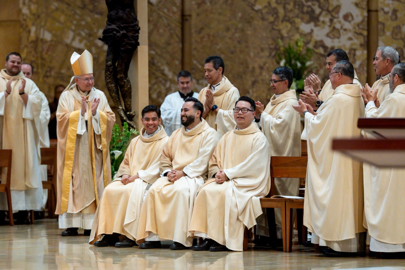 El arzobispo José H. Gomez, junto con los obispos y sacerdotes presentes, aplaude a los tres nuevos sacerdotes durante la Misa de ordenación celebrada el 30 de mayo en la Catedral de Nuestra Señora de los Ángeles. (Joe Garcia III)