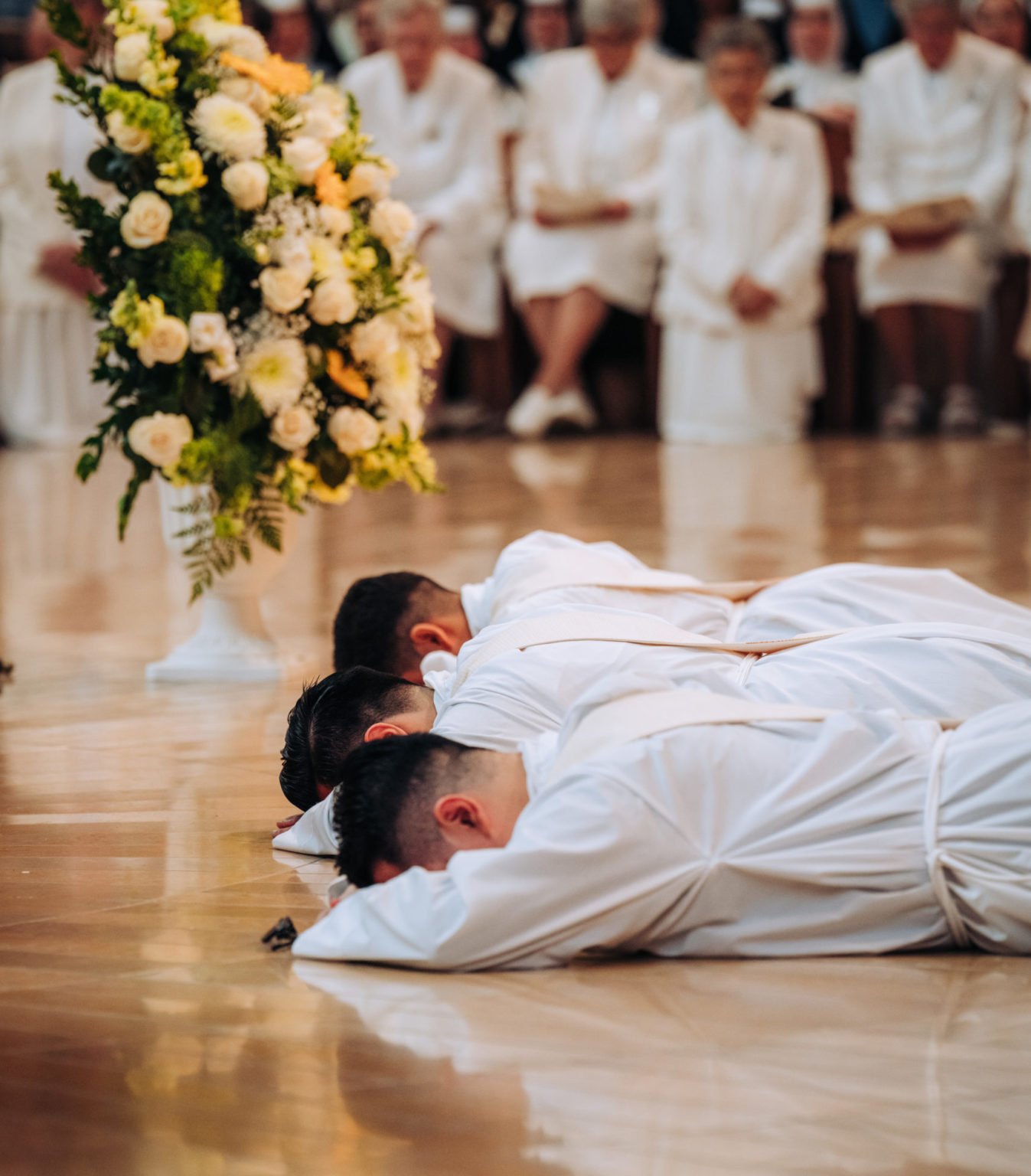 Los tres nuevos sacerdotes yacen postrados ante el altar durante la Misa de ordenación celebrada el 30 de mayo en la Catedral de Nuestra Señora de los Ángeles. (Isabel Cacho)