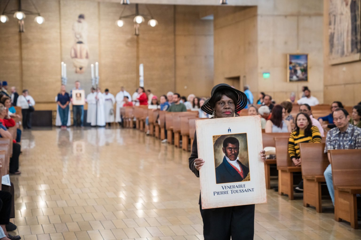 Earlline Anderson porta un retrato del venerable Pierre Toussaint durante la procesión en honor a figuras ejemplares de la Iglesia Católica en Estados Unidos, al inicio de la Misa por la Nación, celebrada el 3 de julio en la Catedral de Nuestra Señora de los Ángeles. (Isabel Cacho)