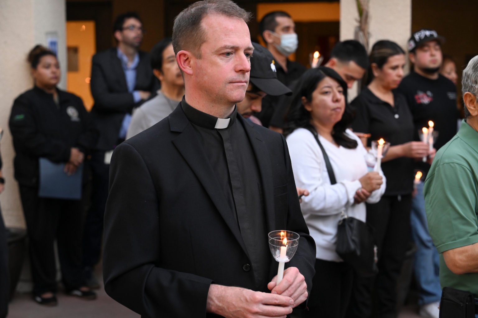 El padre Ethan Southard, párroco de la iglesia St. John Eudes, en Chatsworth, reza durante la vigilia a la luz de las velas del 17 de septiembre. (John McCoy)