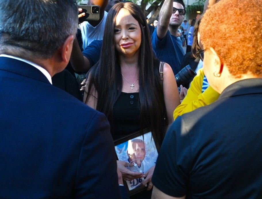 Marina Sabia, prima de Daniel Castillo, víctima del accidente de autobús ocurrido en Chatsworth, recibe las condolencias de la alcaldesa de Los Ángeles, Karen Bass, y del concejal municipal John Lee durante la vigilia del 17 de septiembre de 2026, frente a la iglesia católica St. John Eudes. (John McCoy)