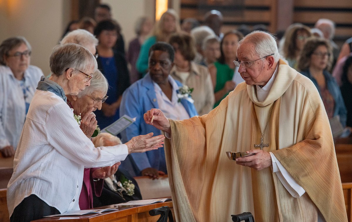 Archbishop Gomez distributes communion at the Oct. 11 Mass at St. John Fisher Church.