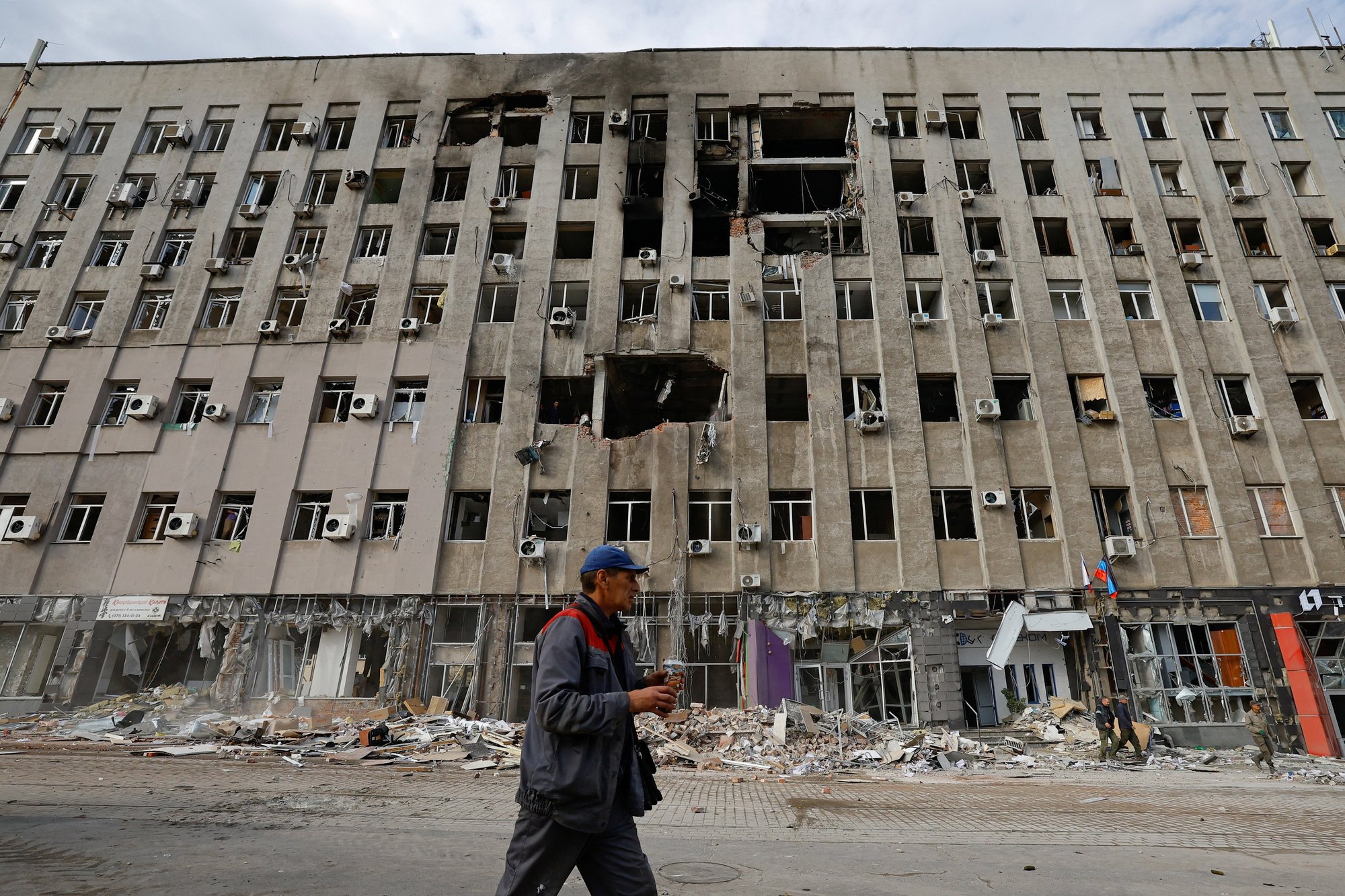 A man walks past a damaged building in Donetsk