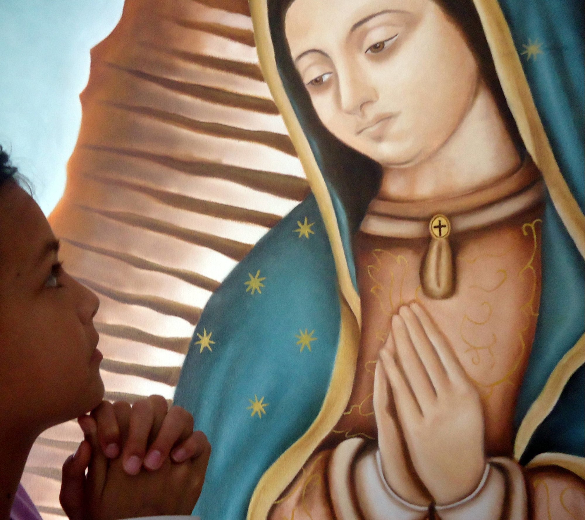 Nuestra Señora de Guadalupe y niña orando frente a ella (Cathopic)